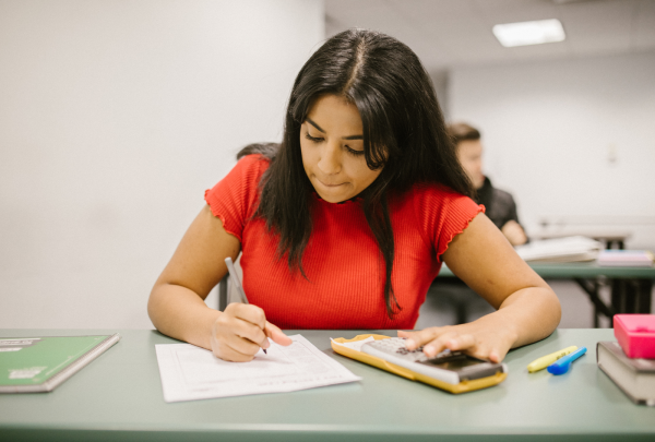 Girl in a red top, taking an exam