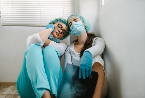 Two tired nurses sitting on the ground