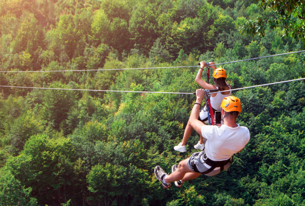 Two adventurers ziplining in the forest